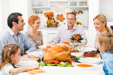Family at the dinner table at the Thanksgiving day.