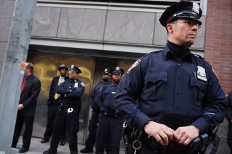 NEW YORK, NY - NOVEMBER 28: Police stand guard as demonstrators, joined by members of the Occupied Wall Street Movment, march near Baruch College in Manhattan to protest against proposed tuition increases over the next few years at the state the school system  on November 28, 2011 in New York City. A heavy police prence met the protesters as city University of New York trustees prepared to vote Monday afternoon on a series of tuition increases at the school.  (Photo by Spencer Platt/Getty Images)